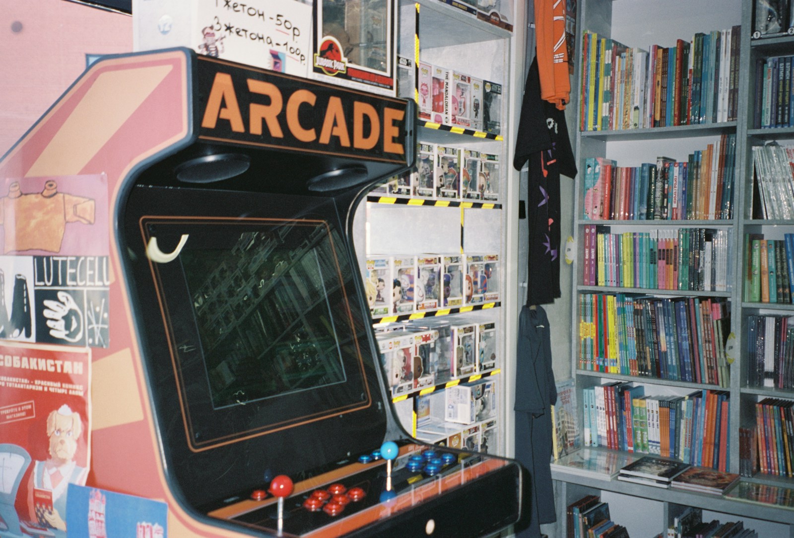 An arcade machine in front of a bookshelf